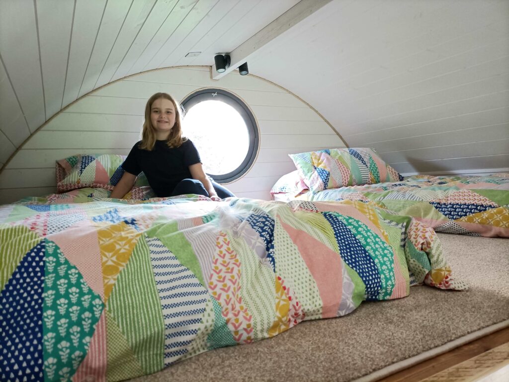 Mezzanine area of pod showing young girl and two single beds